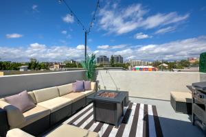 a patio with a couch and a table on a roof at Downtown Darling by AvantStay Rooftop Deck View in Los Angeles