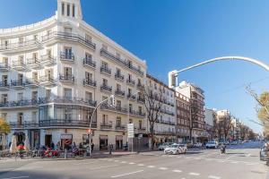 a large white building on a city street with cars at Maravilloso estudio en Chamberi. Metro Quevedo in Madrid