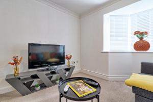 un soggiorno con TV a schermo piatto su un tavolo di Hythe Hill Home a Colchester