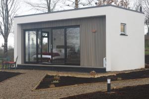 uma pequena casa com uma grande porta de vidro em LakEscape - Waterfront Self- Catering Cabins em Enniskillen