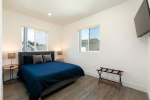 洛杉磯的住宿－Downtown Darling by AvantStay Rooftop Deck View，一间卧室设有一张床和两个窗户。