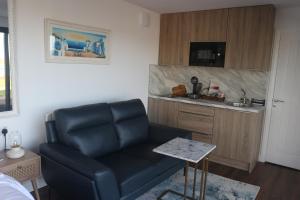 a living room with a couch and a kitchen at LakEscape - Waterfront Self- Catering Cabins in Enniskillen