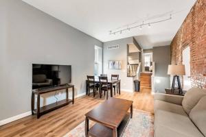 a living room with a couch and a tv at Settle into Soulard 4 Beds 2 full baths in Soulard