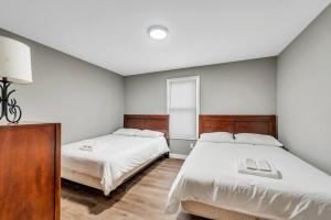 - une chambre avec 2 lits et des draps blancs dans l'établissement Settle into Soulard 4 Beds 2 full baths, à Soulard