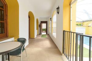 um corredor com paredes amarelas, uma mesa e cadeiras em Casa Rural "compartida" La Loma em Granada
