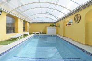 uma piscina interior com tecto de vidro e uma piscina em Casa Rural "compartida" La Loma em Granada