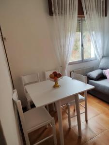 uma mesa branca e cadeiras numa sala de estar em Casa da Fontiña em Seoane