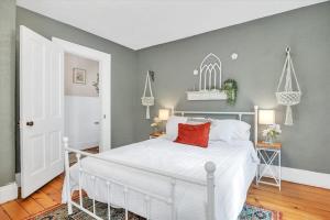 1 dormitorio con cama blanca y pared gris en Deck & Modern Amenities! Hollyhock Hideaway, en South Bend