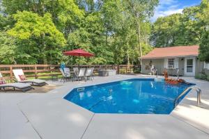 una piscina en un patio trasero con mesa y sillas en Deck & Modern Amenities! Hollyhock Hideaway, en South Bend