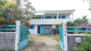 una casa bianca con porte blu davanti di Ti' cocon des îles a Le Moule