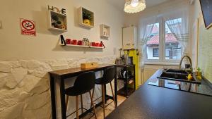 a kitchen with a counter and a bar with two chairs at Tusmorez Central Apartment in Târgu-Mureş