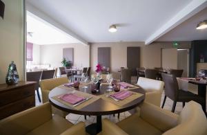 a dining room with a table and chairs in a restaurant at Hôtel de la Louée in Haute-Goulaine