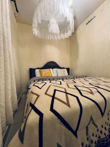 a bedroom with a bed and a chandelier at Ample Residence in Nairobi