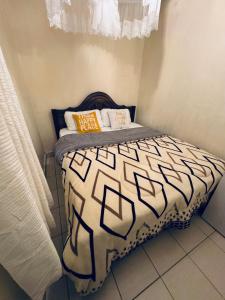 a small bedroom with a bed in a room at Ample Residence in Nairobi