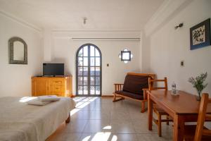 Suites Sevilla في بوبلا: غرفة نوم بسرير وطاولة وكرسي