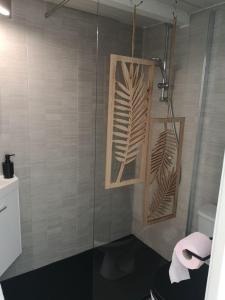 uma casa de banho com um chuveiro, um WC e uma toalha em La Maison Bleue em Gruissan