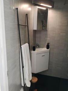 uma casa de banho com um lavatório branco e um espelho. em La Maison Bleue em Gruissan