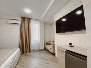 a hotel room with a bed and a tv on the wall at Royal Renaissance Hotel in Yerevan