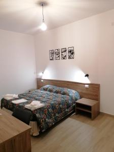 a bedroom with a bed and a table at CLASS ROOMS AFFITTACAMERE in SantʼAnna Arresi