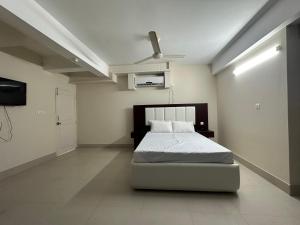 Schlafzimmer mit einem Bett und einem Deckenventilator in der Unterkunft Hotel Kingfisher - Barishal in Barishal