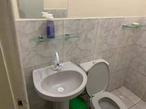 a bathroom with a toilet and a sink at 102 verão kit exclusiva in Brasilia