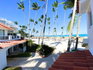 蓬塔卡納的住宿－AZUL CARAIBICO Beach Club & SPA，享有棕榈树海滩和大楼的景色