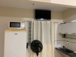a room with a fan and a television on a wall at 102 verão kit exclusiva in Brasilia