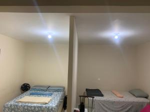 a bedroom with two beds and two lights on the ceiling at 102 verão kit exclusiva in Brasilia +6 photos