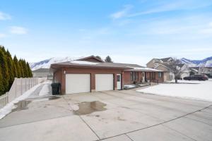 a house with a garage and mountains in the background at Spanish Fork Retreat in Spanish Fork