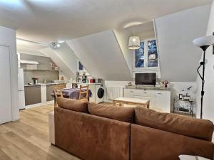 sala de estar con sofá y cocina en L'escapade Chelloise *Paris*, en Chelles
