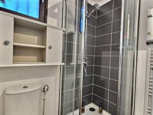 La salle de bains est pourvue d'une douche avec une porte en verre. dans l'établissement L'escapade Chelloise *Paris*, à Chelles