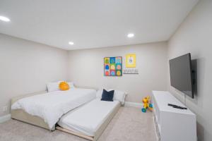 1 Schlafzimmer mit 2 Betten und einem Flachbild-TV in der Unterkunft Spanish Fork Retreat in Spanish Fork