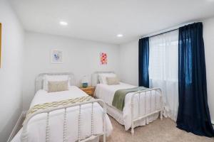 2 Betten in einem weißen Zimmer mit Fenster in der Unterkunft Spanish Fork Retreat in Spanish Fork
