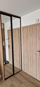 twee glazen schuifdeuren in een kamer met hout bij Apartamenty Paderewski 2 in Bielawa