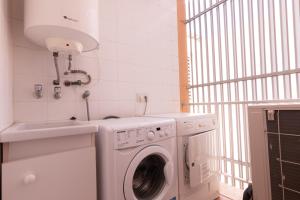a laundry room with a washing machine and a sink at Holiday beach homes Romaní II in Colònia de Sant Jordi