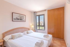 a bedroom with two beds and a window at Holiday beach homes Romaní II in Colonia Sant Jordi