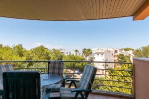 a balcony with chairs and a table and a view at Holiday beach homes Romaní II in Colònia de Sant Jordi
