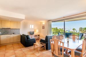 a kitchen and living room with a table and chairs at Holiday beach homes Romaní II in Colònia de Sant Jordi