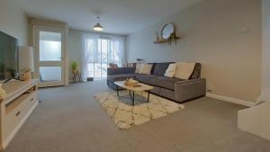 ein Wohnzimmer mit einem Sofa und einem Tisch in der Unterkunft 2BD Home: Locale Near Old Town & Fast London Links in Stevenage