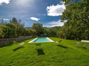 una piscina en un patio de césped con 2 sillas de césped en Holiday Home Pietreto by Interhome, en Ravigliano