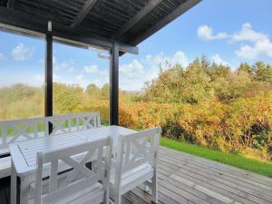 eine Veranda mit einem weißen Tisch und Stühlen auf einer Terrasse in der Unterkunft Holiday Home Analia - 300m to the inlet in The Liim Fiord by Interhome in Fur