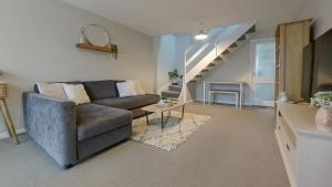 ein Wohnzimmer mit einem Sofa und einer Treppe in der Unterkunft 2BD Home: Locale Near Old Town & Fast London Links in Stevenage