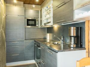 a kitchen with stainless steel cabinets and a sink at Holiday Home Ruskatupa 2 by Interhome in Sirkka