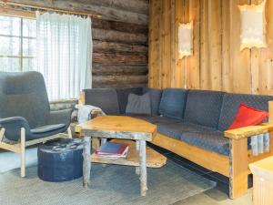 a living room with a couch and a table and chairs at Holiday Home Ruskatupa 2 by Interhome in Sirkka