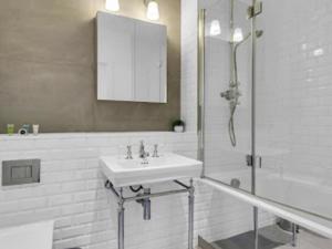 a white bathroom with a sink and a shower at Apartment Regents Park Serviced Apartment-2 by Interhome in London