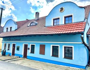 um edifício azul e branco com um telhado vermelho em Penzion Na Zelnicách em Ratíškovice