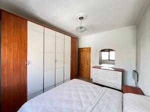 a bedroom with a white bed and a wooden cabinet at Tirana Center 2Bedrooms in Tirana