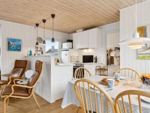 een keuken en eetkamer met een tafel en stoelen bij Holiday Home Tammo - 900m from the sea in NW Jutland by Interhome in Torsted