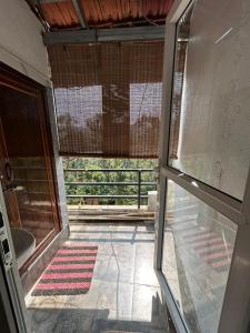 an empty room with a view of a bathroom with a window at Sana Riverside in Madikeri