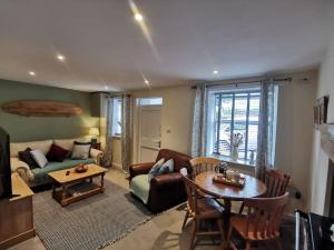 a living room with a couch and a table at Cosy Cottage in a quaint village in North Devon. in Abbotsham
